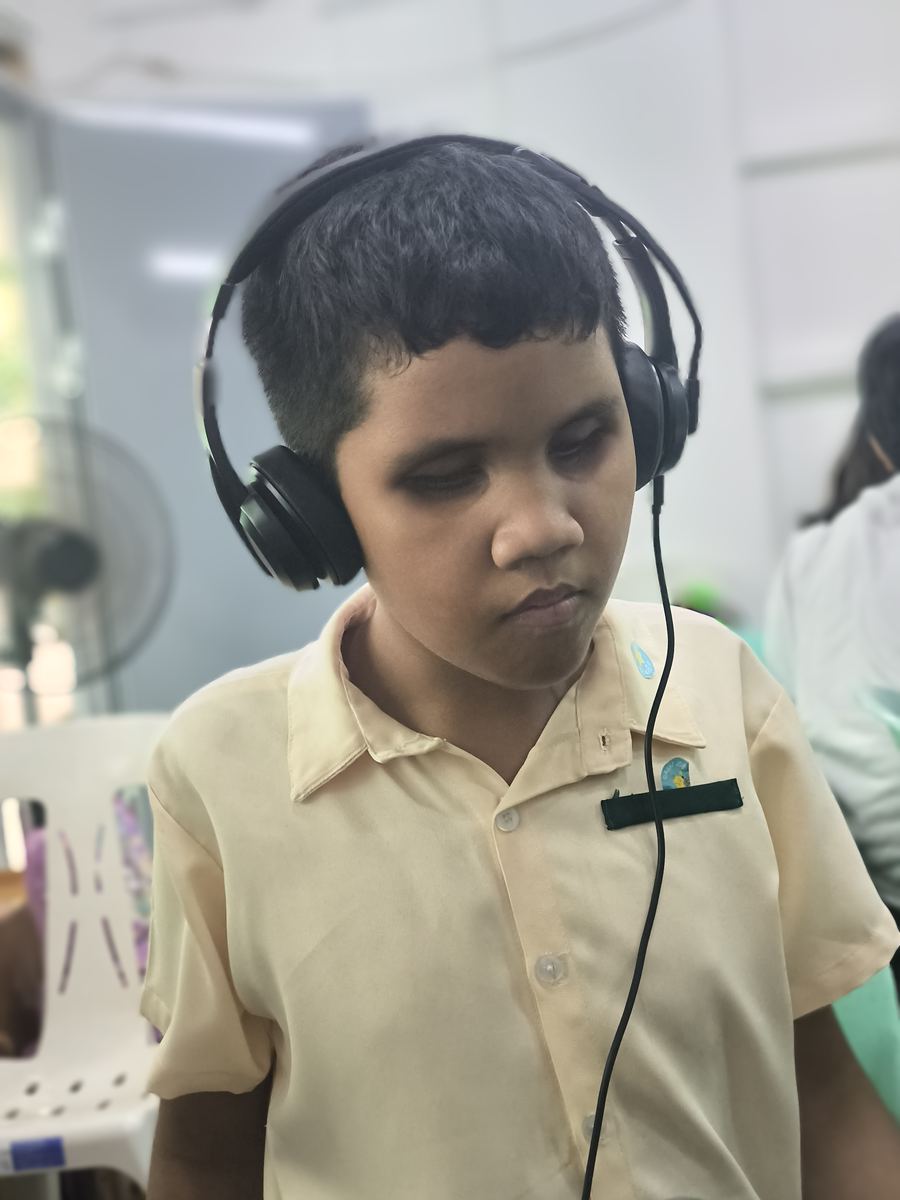 A student wearing headphones listens to a voice description.